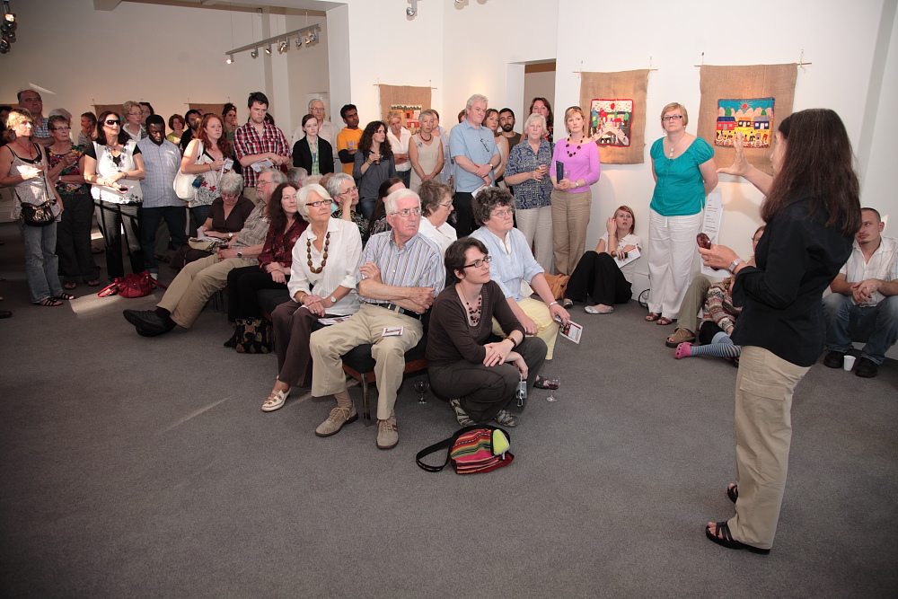 Attendees listening intently to curator Roberta Bacic at the exhibition opening event. (Photo: Martin Melaugh)