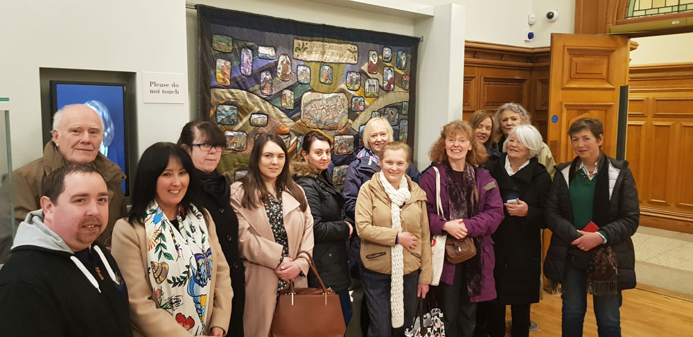 Participants from “Making the Future” Project pictured with Breege Doherty, Conflict Textiles, at the Guildhall, after viewing the quilt by Deborah Stockdale: “The Plantation: Process, People, Perspectives”. (Photo: Donal Mc Anallen)                     
