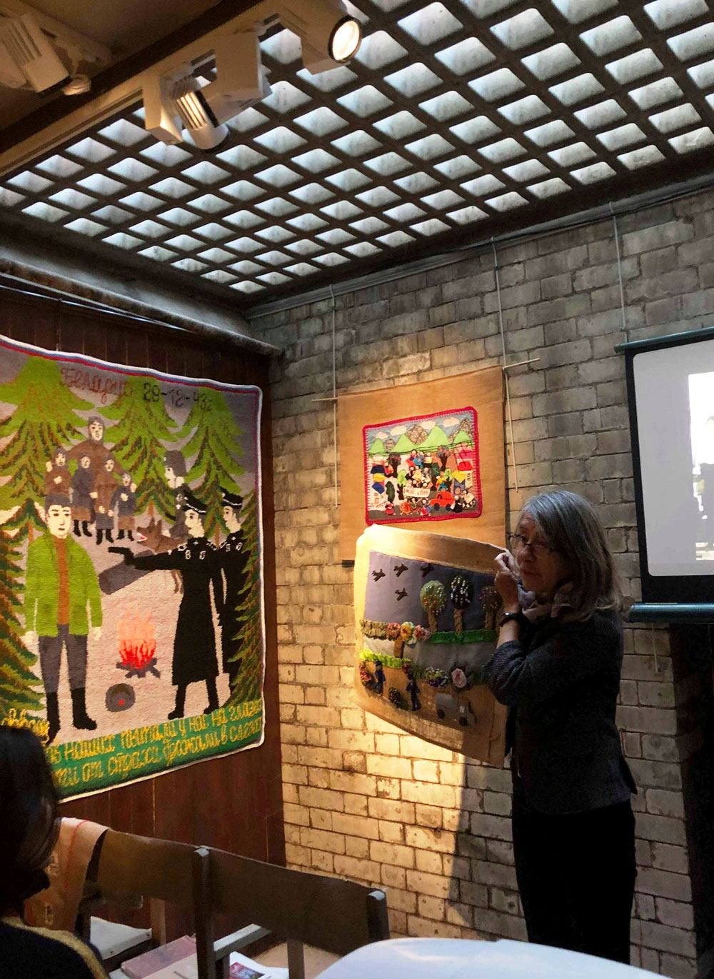Roberta Bacic explaining the detail of an arpillera at the Gallery of Everything. (Photo: Nelta Kasparian)