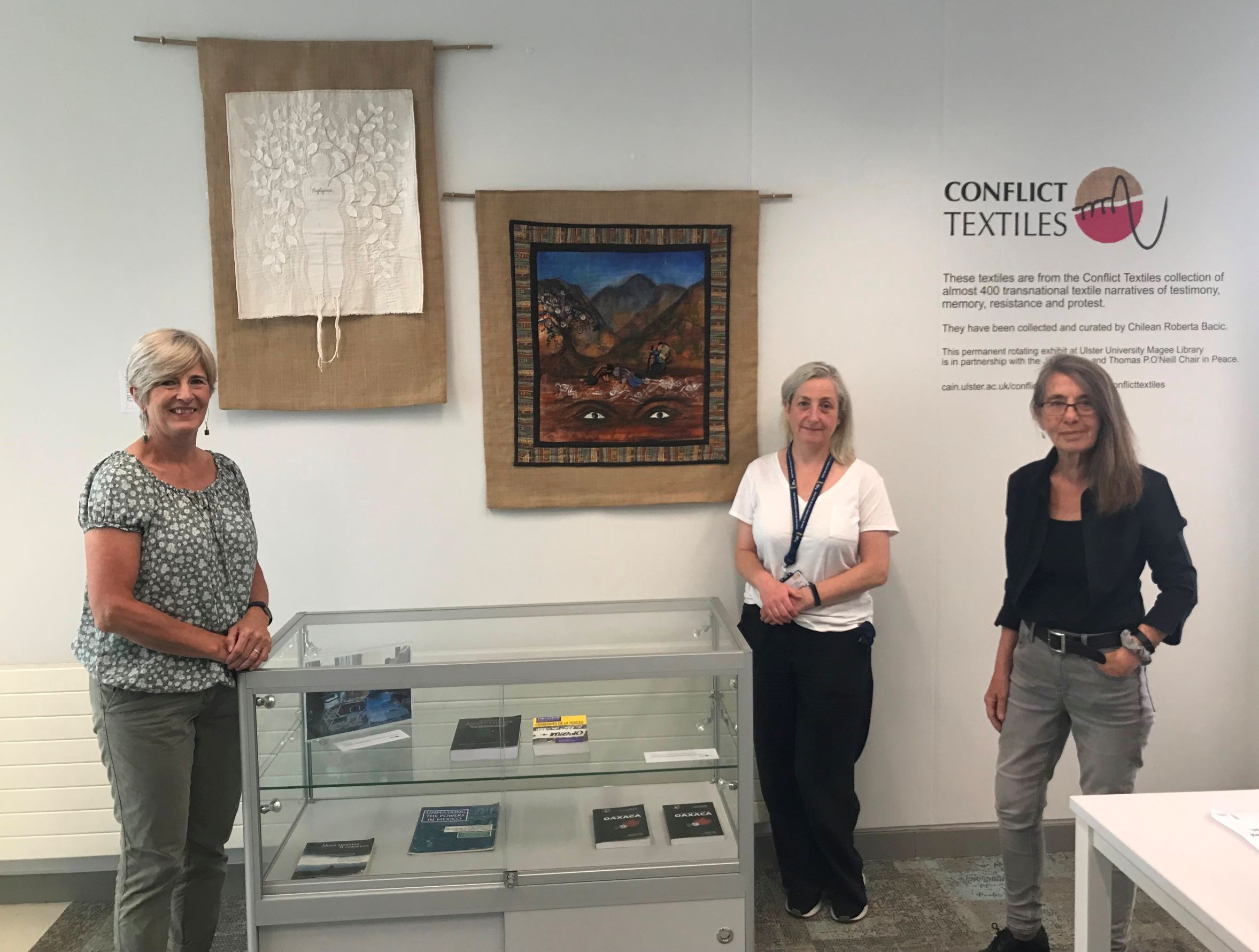 Gillian Robinson & Roberta Bacic with  Rosina Doherty-Allan, Magee Campus Library Manager, at the installation of  Mexican arpilleras, which marks the start of the exhibition “Following the Footsteps of the Disappeared 2021”. (Photo: Conflict Textiles)
