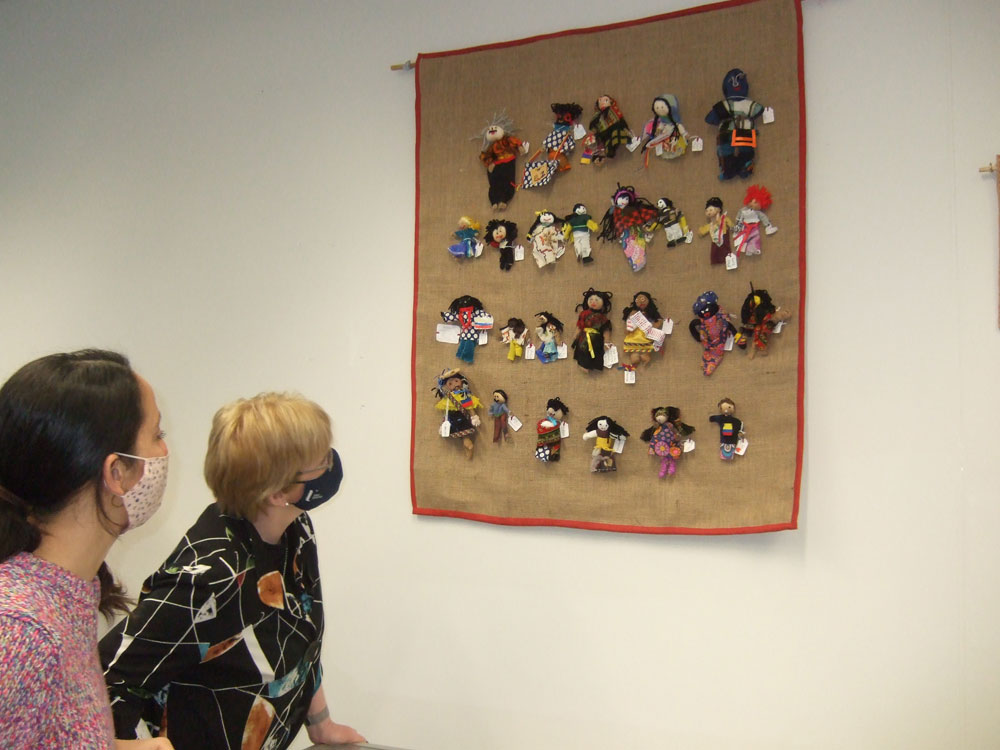 Marina Echeverria - whose doll is part of this collective banner -    and Professor Terri Scott, Ulster University, engaging with the textile. (Photo: Breege Doherty)