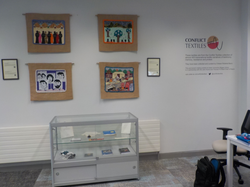 Four Chilean arpilleras from the late 1980s themed on enforced disappearance and police repression, on display with related memorabilia in Magee Campus Library.  (Photo: Roberta Bacic)