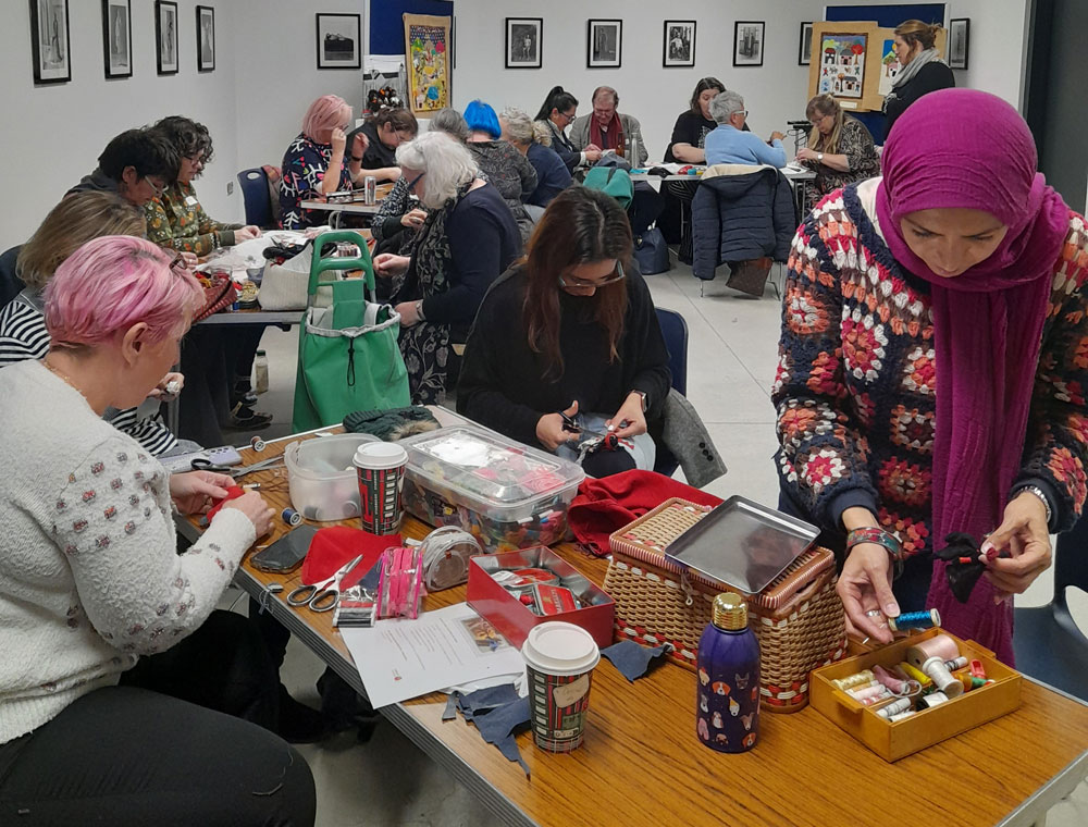Participants engrossed in the 'hands on' process of creating arpillera dolls themed on displacement during the full day workshop.<br/a> (Photo: Breege Doherty)